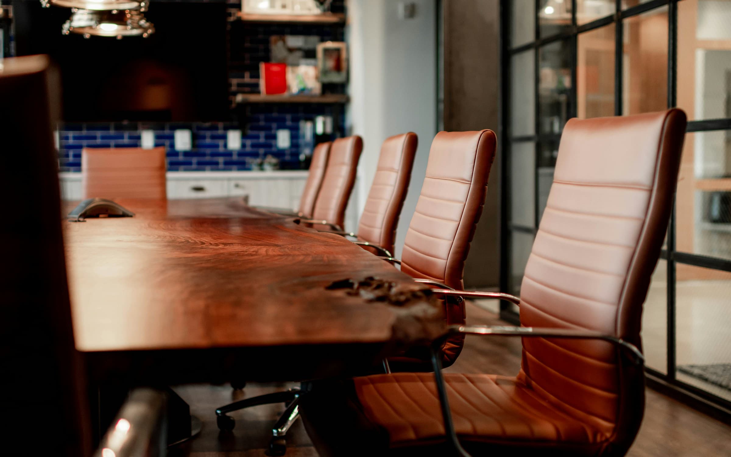 A board meeting at a dark table, no handshake, no readable text